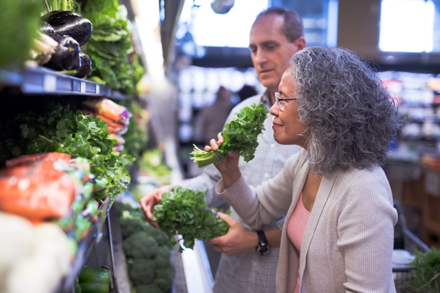 a woman shopping for fresh greens at a supermarket